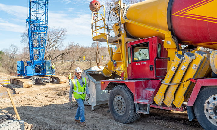 Worker in front of a cement mixer truck.
