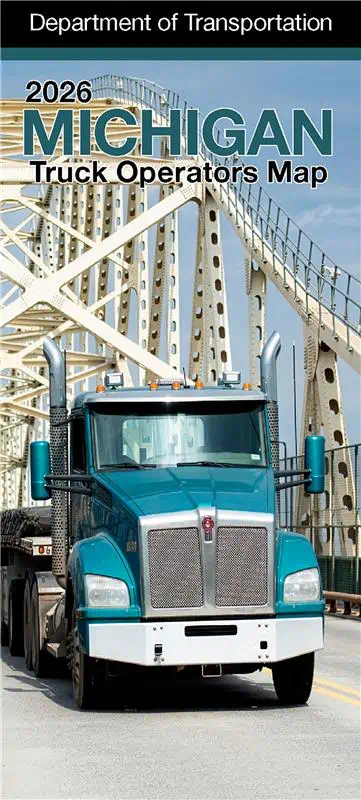 The cover of the Michigan Truck Operators Map showing a semi truck on a Michigan freeway at sunrise.
