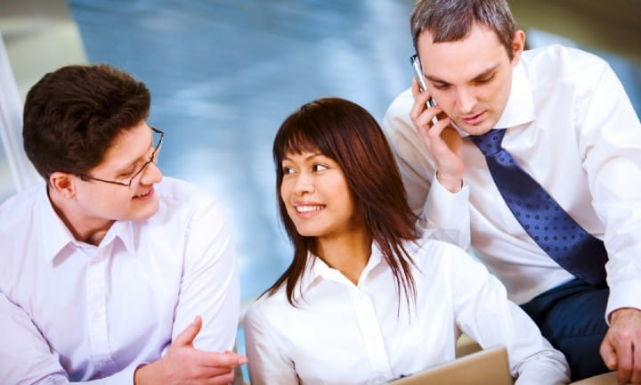 Diverse woman and men in business attire in an office setting.