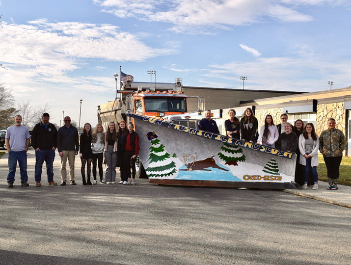 Ovid-Elsie High School art students introduced their safe winter driving-themed plow blade. They were joined by representatives from the Clinton County Road Commission and  MDOT University Region Engineer Greg Losch.