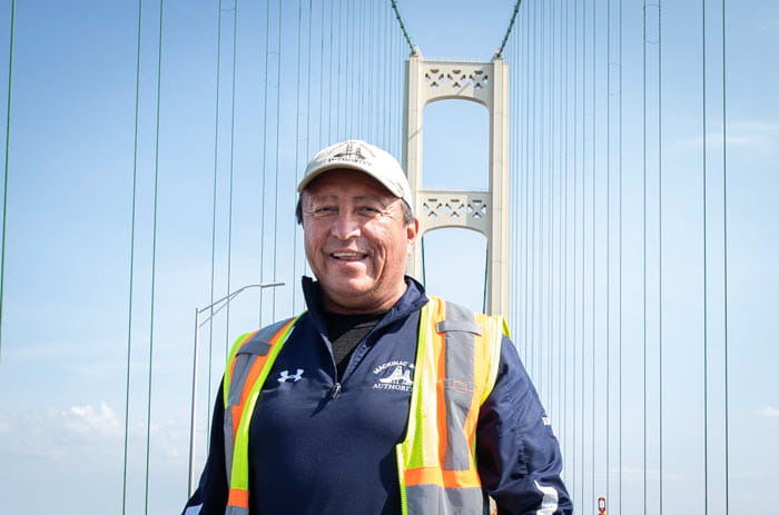 Pat Rickley stands in front of the Mackinac Bridge.
