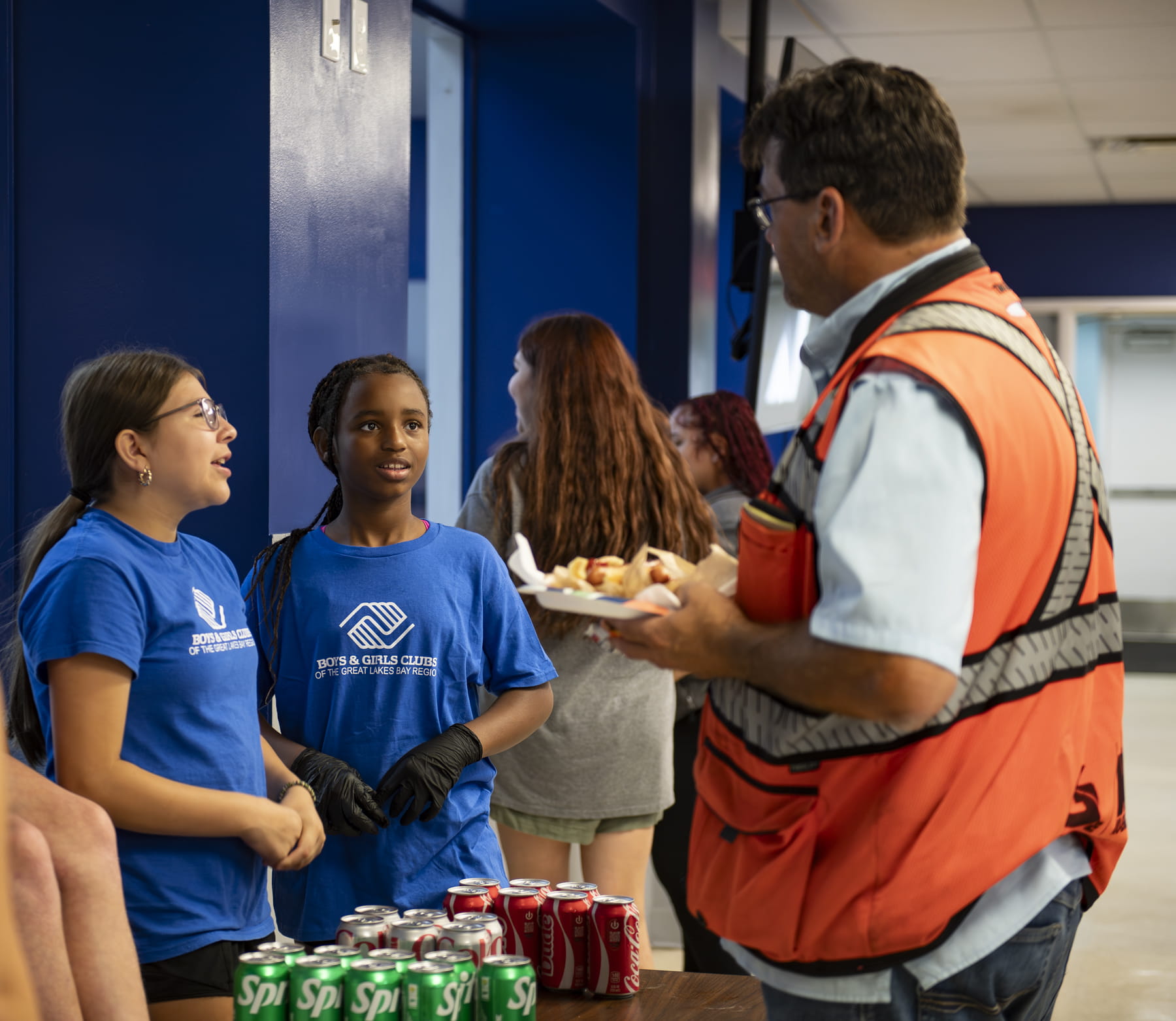 Boys and Girls Club Torch Club members ask questions while serving lunch to a worker from the Lafayette Street bridge project.