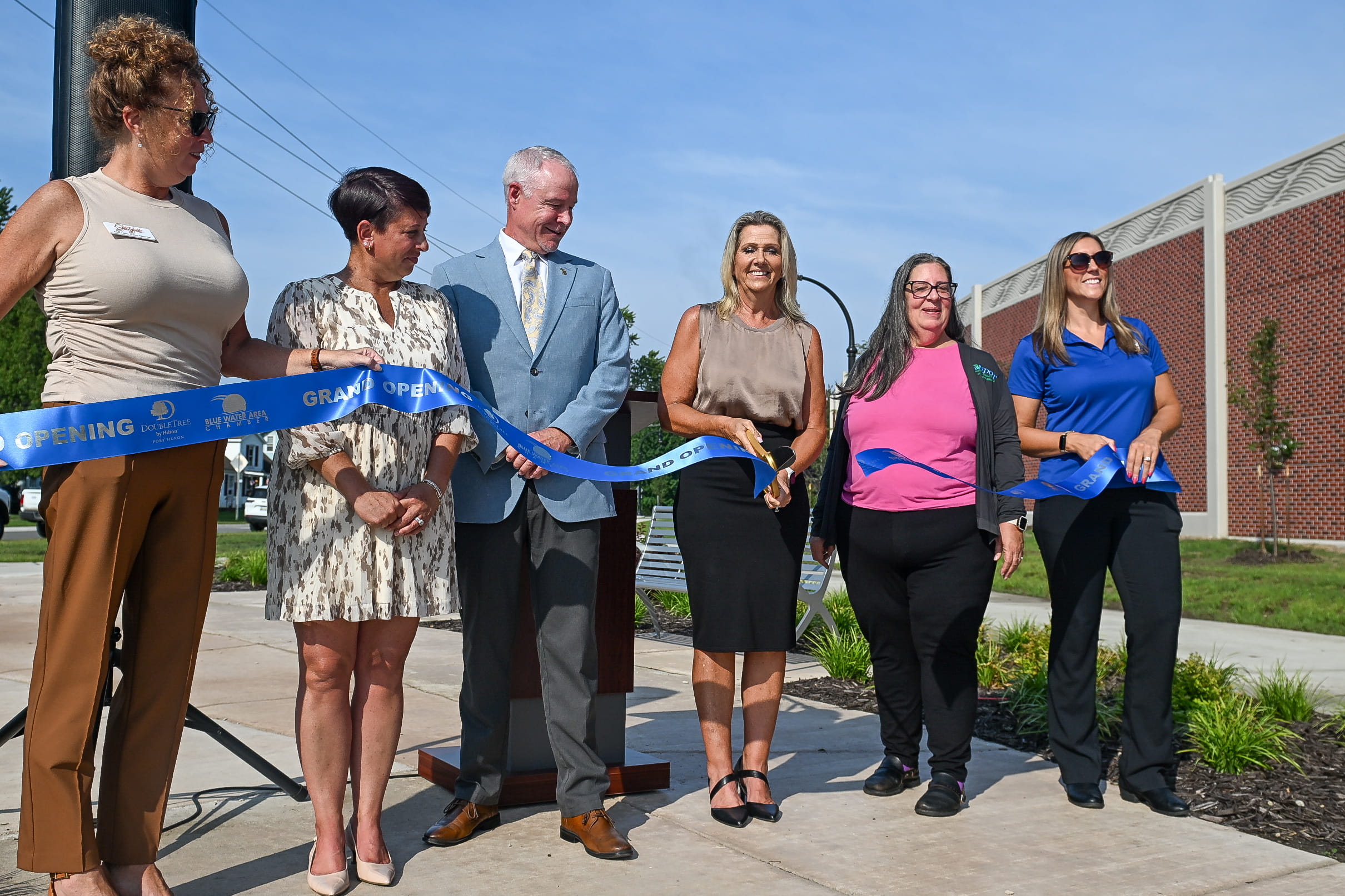 Local officials and MDOT staff celebrate the opening  of the Scott Avenue path and greenspace with a ribbon-cutting celebration.