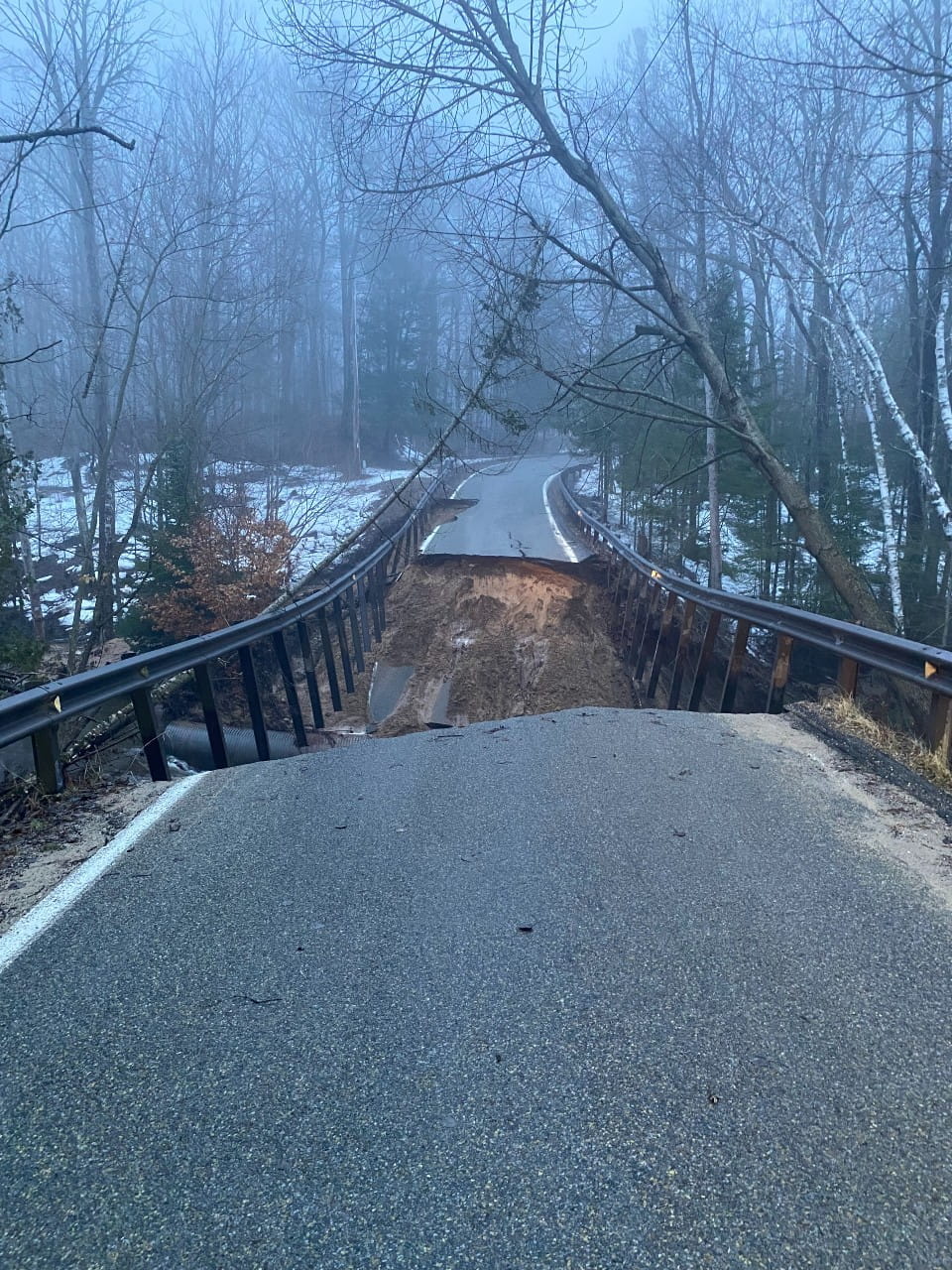 Damage to bridge and road from a culvert washout, slope failure closes M-119 in Emmet County