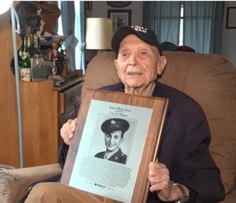 At his home in Ithaca recently, 103-year-old Ceo Bauer holds a copy of the plaque honoring him at the MDOT Seney Rest Area. Bauer, a decorated World War II veteran, was an engineer with MDOT for 31 years. He retired in 1980. (MDOT photo)