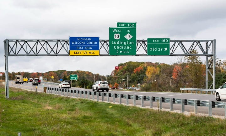 An ancillary structure supporting directional freeway signs over a freeway.