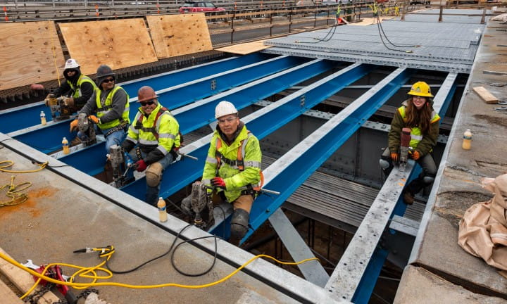 A diverse group of men and women working on the US-31 bascule bridge in Grand Haven.