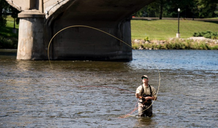 Man fishing near bridge.