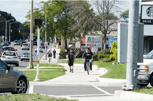 Bicyclist riding down city street.