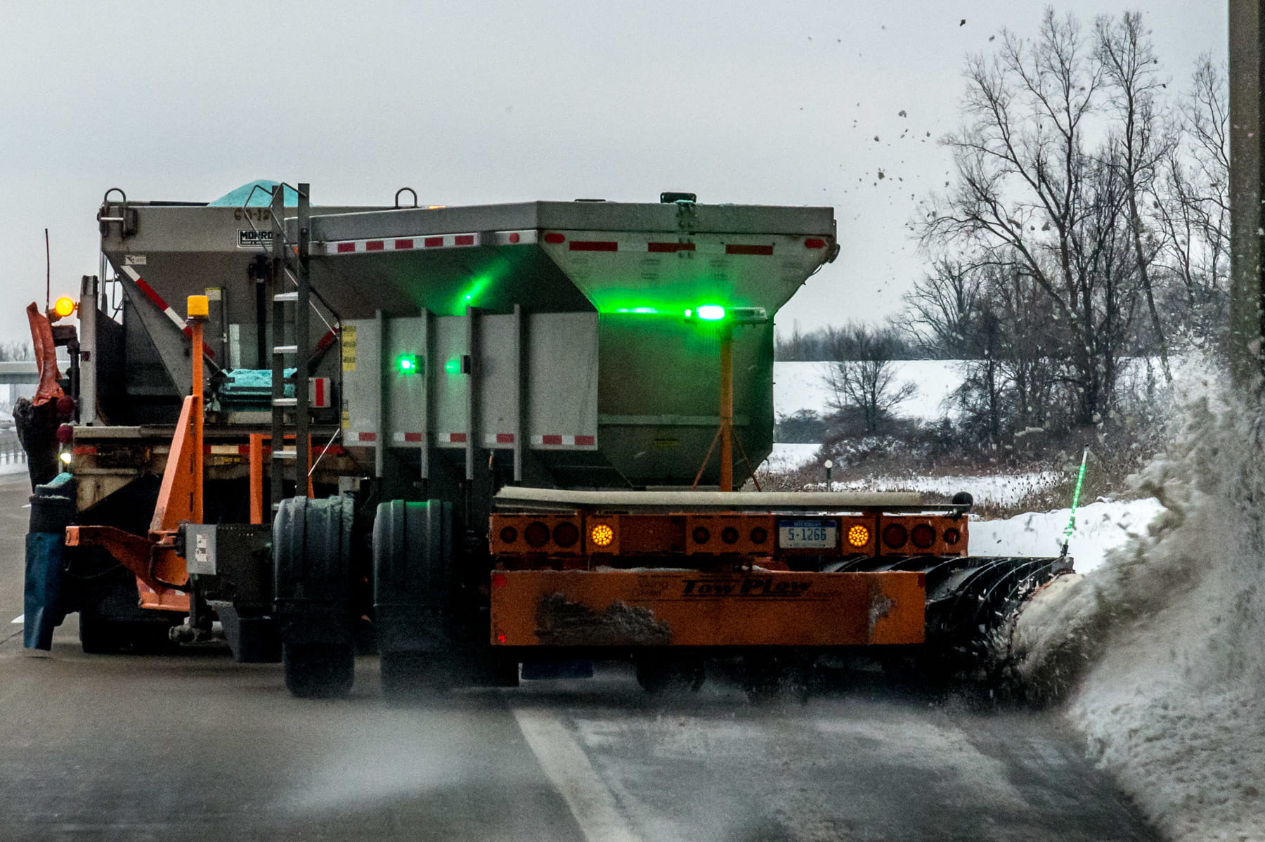 Winter maintenance vehicle with green strobe lights activated.