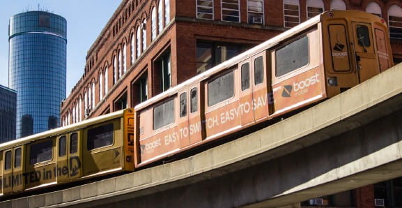 Detroit’s People Mover, an elevated train, travels past a brick building.