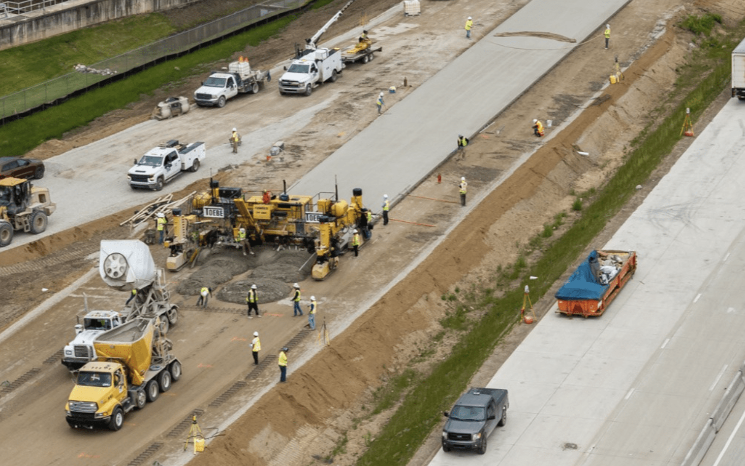 An overhead shot of a road crew paving a highway.