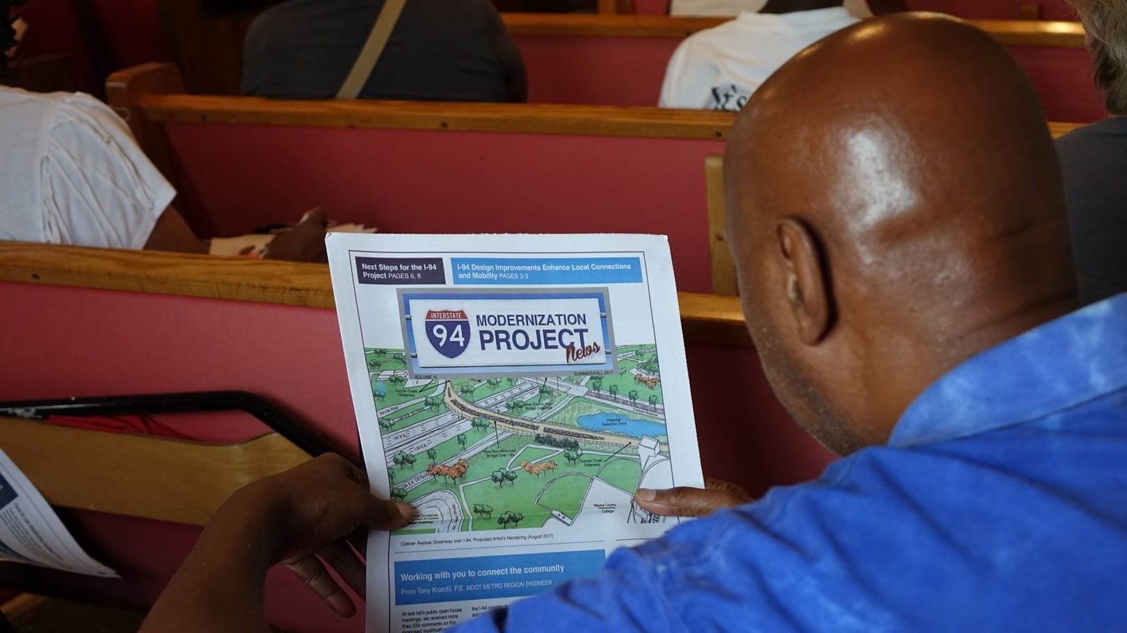 An African-American man reads an I-94 newsletter.