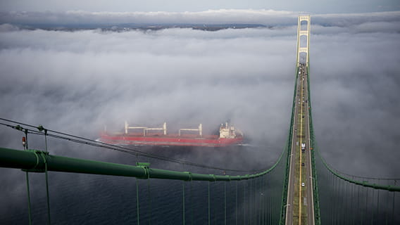 A freighter in fog going under the Mackinac Bridge.