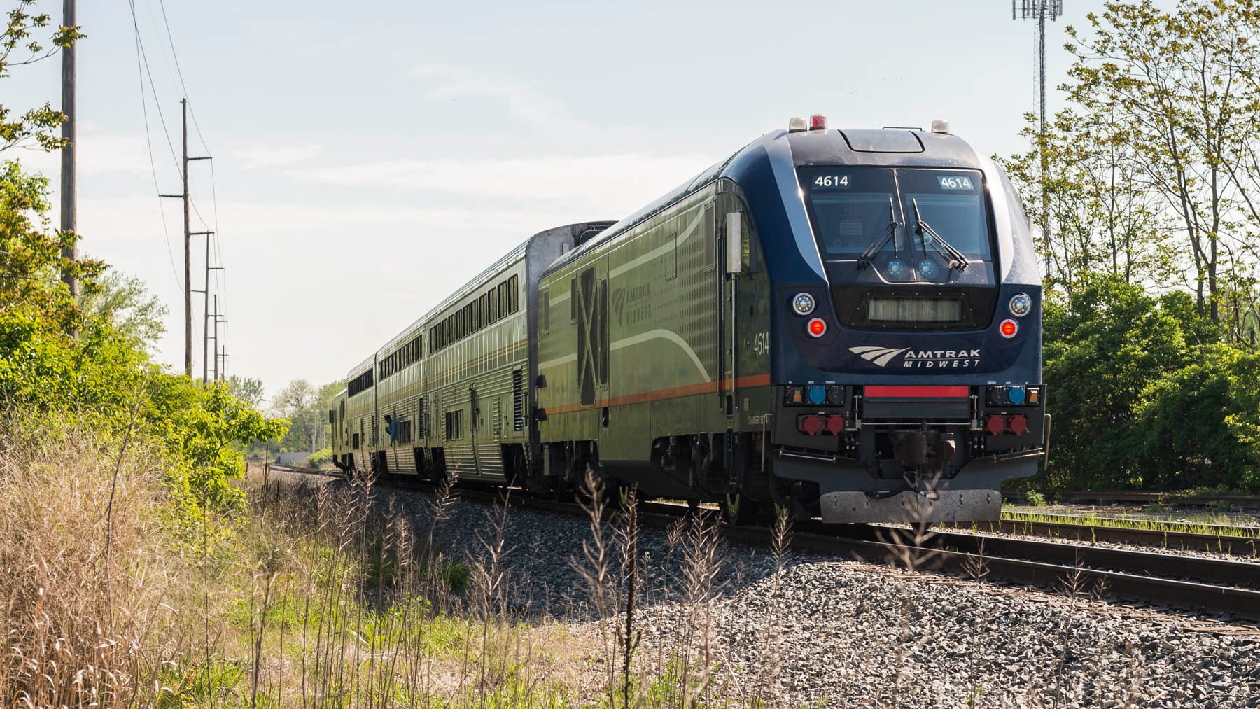An Amtrak passenger train near a rural area.
