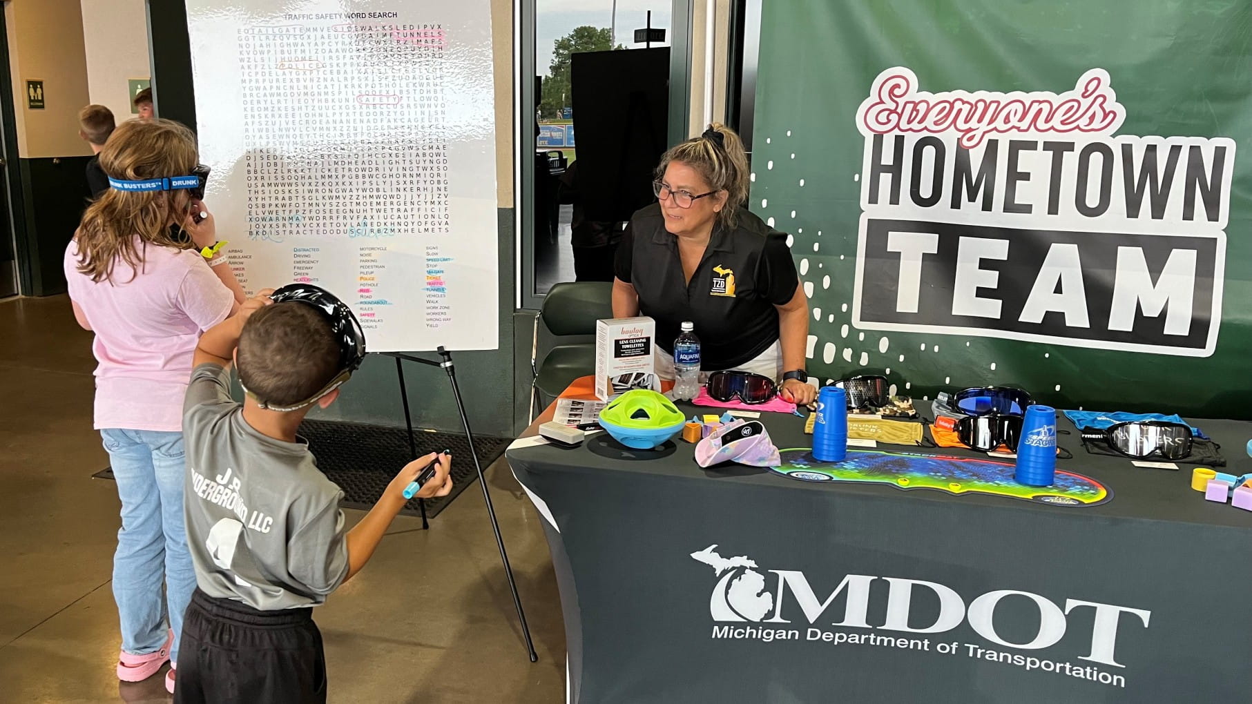One of MDOT's traffic and safety engineers with two children at a safety event.