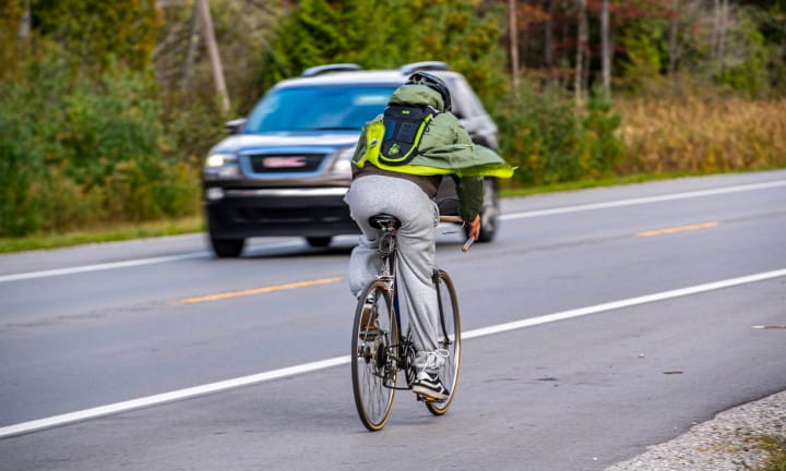A bicyclist and motorist share the road on rural Michigan road.