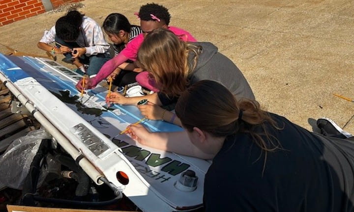Heritage High School art students work to put finishing touches on their plow blade.