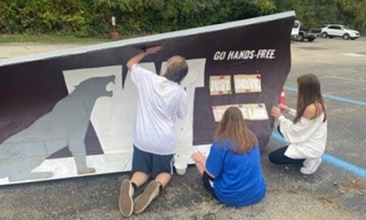 Western High School art students work to paint school spirit on their plow blade. 