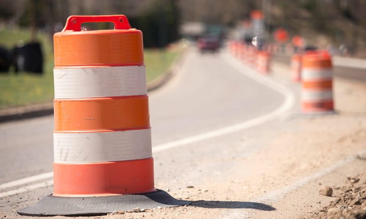 Orange barrels set up in an active work zone.