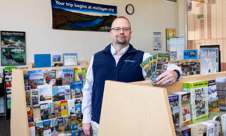 Welcome center staff show off brochures.