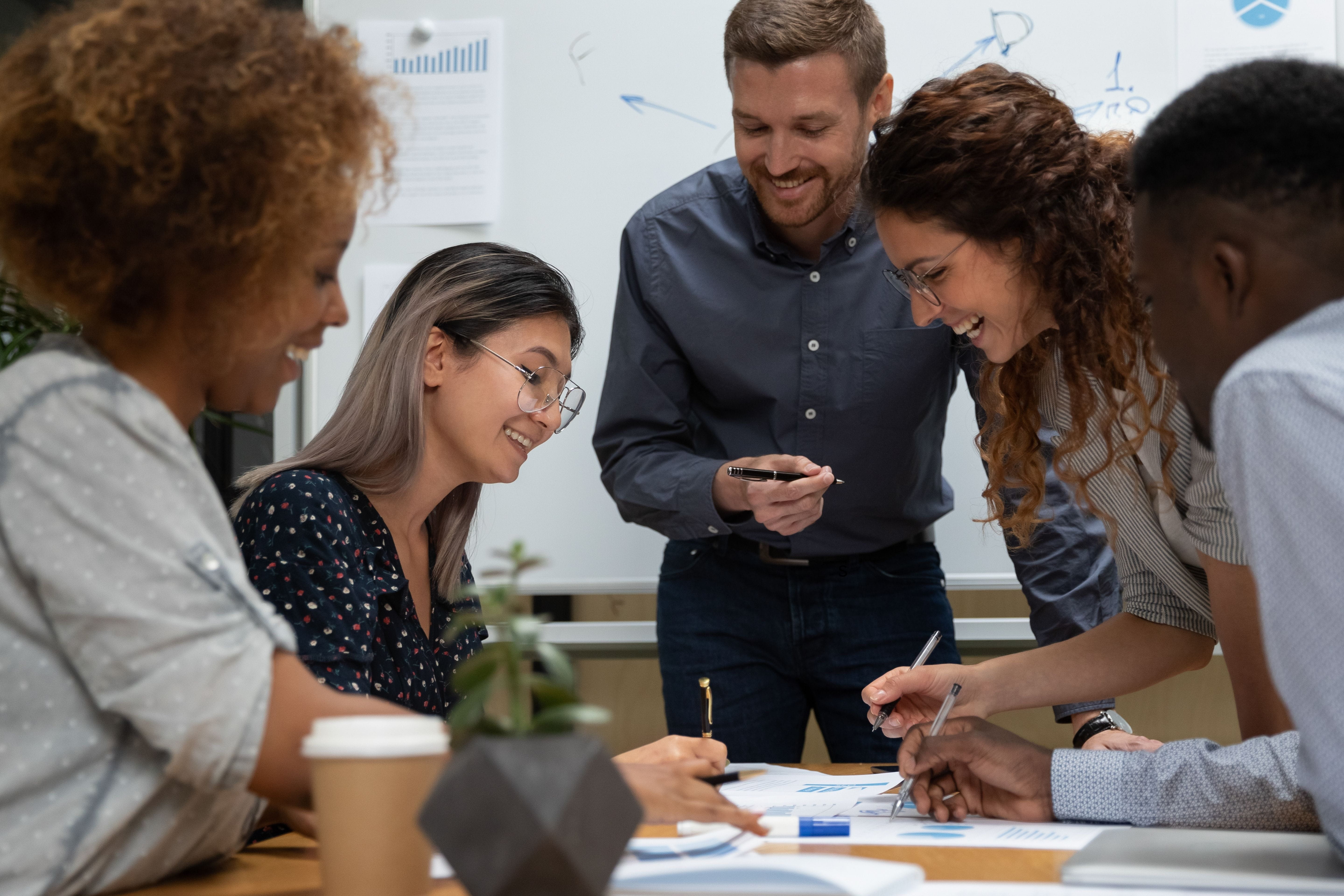People smiling at work around a table