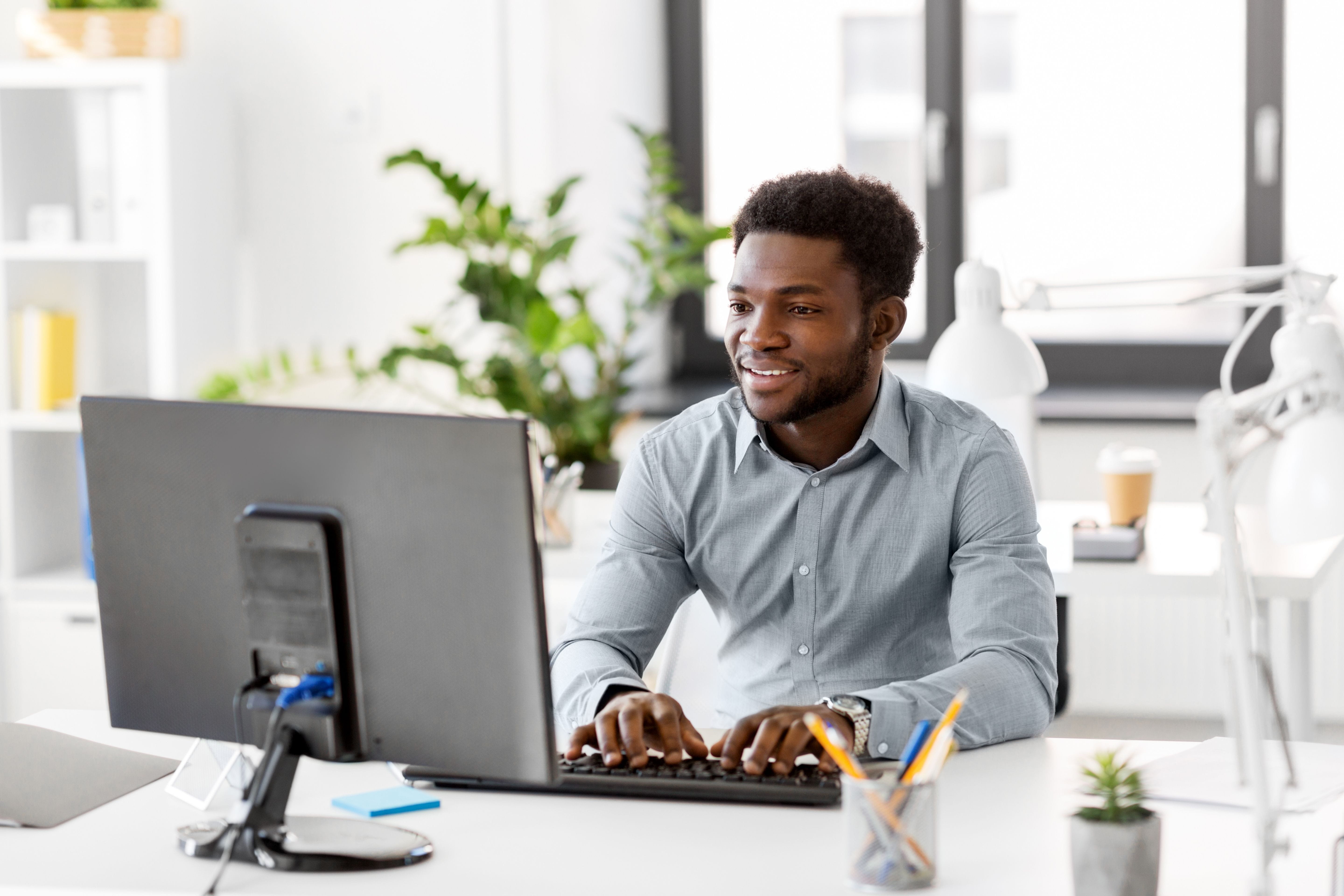 Person smiling and typing at a computer