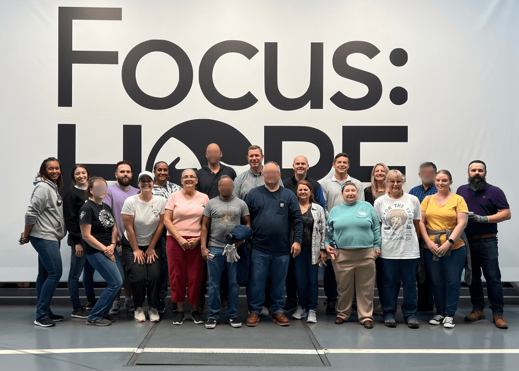 Large group standing in front of focus hope sign