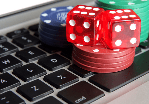 Dice and gambling chips on a keyboard to signify online gaming