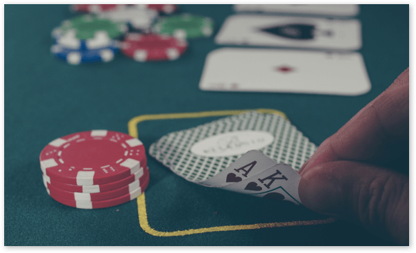 cards on a table held by a poker player