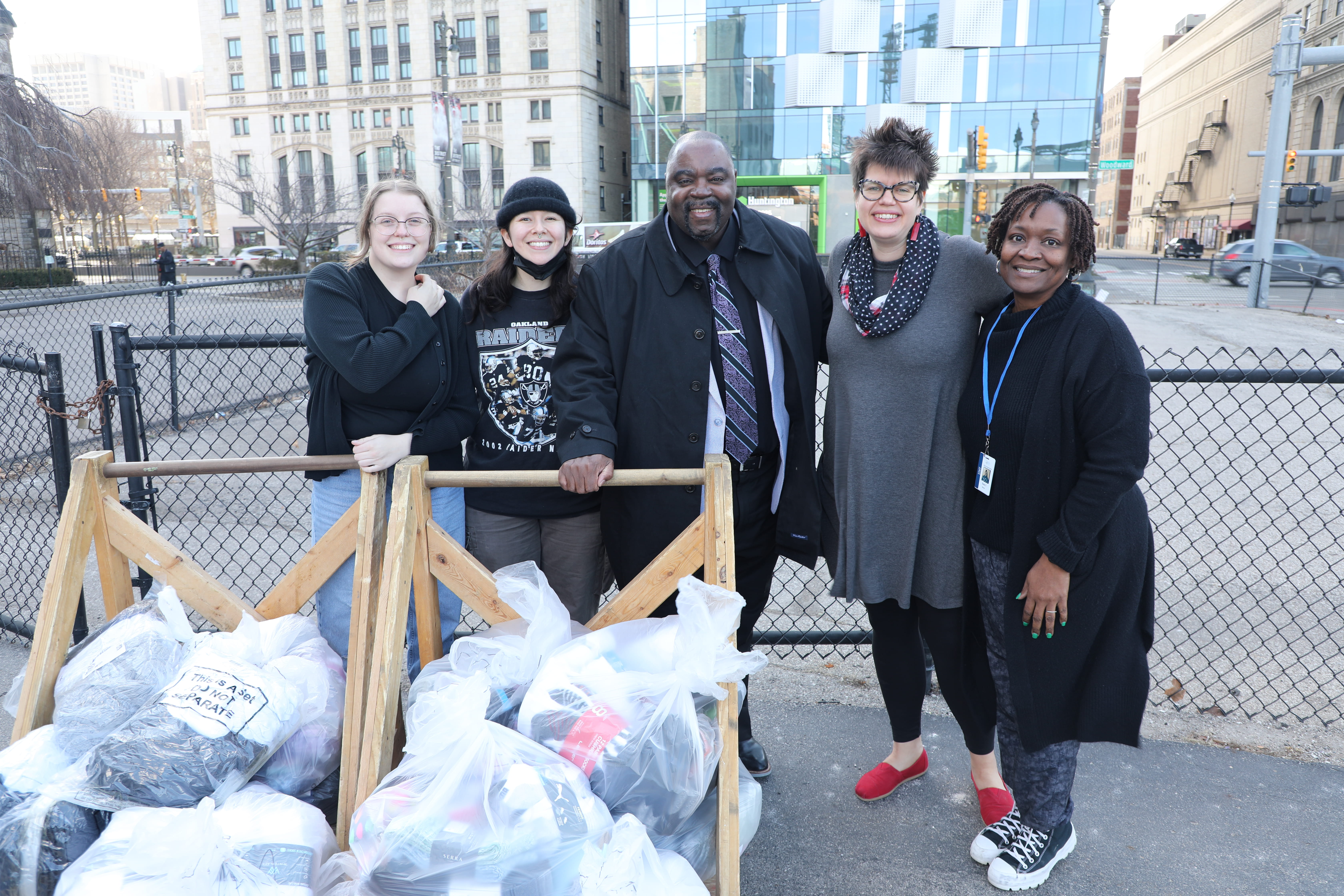 Group standing smiling with socks in garbage bags