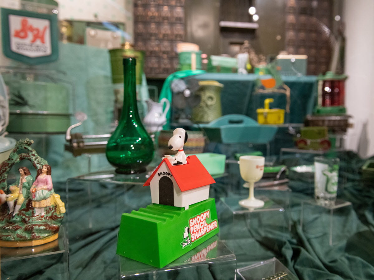Several artifacts that are the same shade of green in an exhibit case.