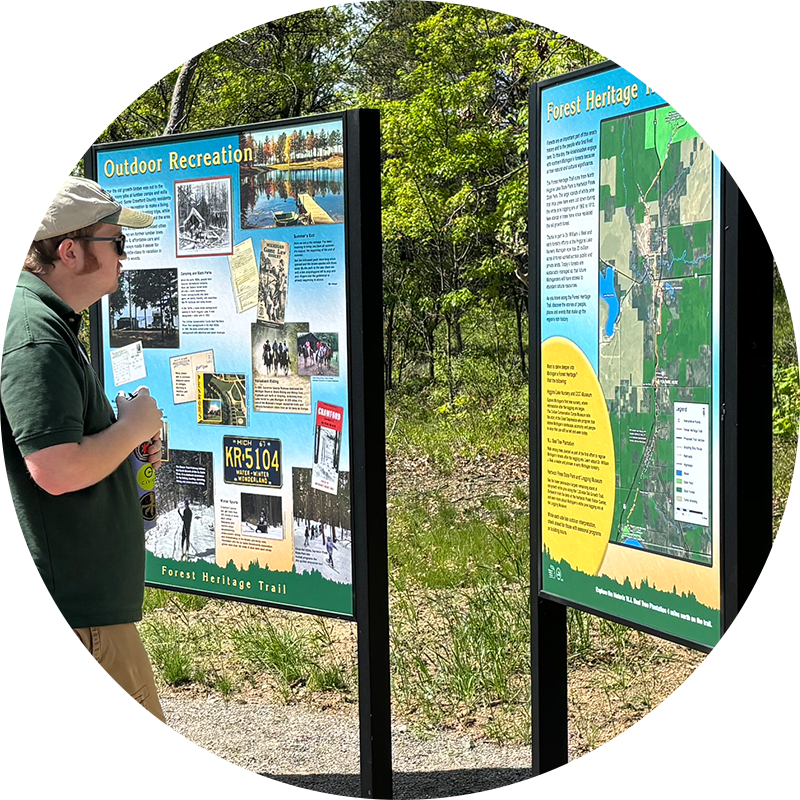 A man looking at two interpretive panels.