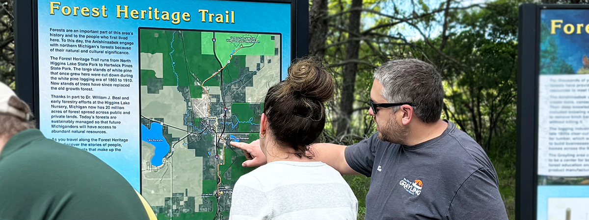 Two people reading a heritage trail sign.