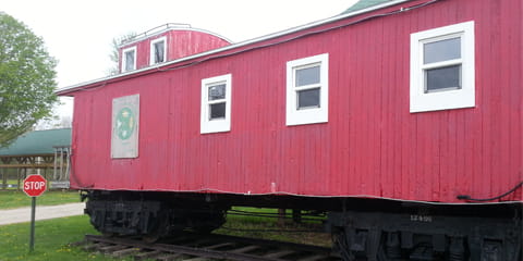 Red caboose with white-trimmed windows