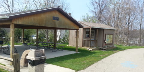Open-air pavilion with picnic tables, bikes; Black River in background.