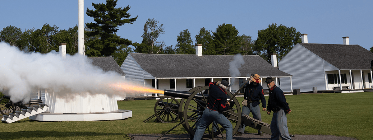 Civil War reenactors firing a cannon at Fort Wilkins.