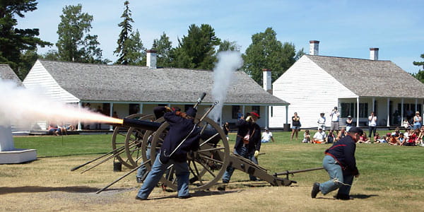 Civil War artillery encampment includes cannons being fired