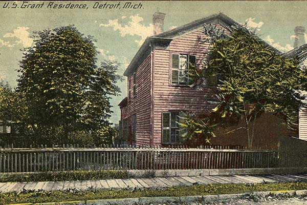 Color postcard of a pink two-story clapboard home with a picket fence