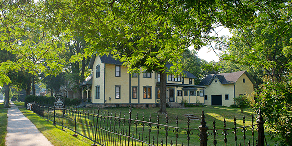 The Mann House, its black gate and bright green lawn. 