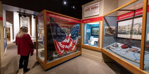 A visitor looks at a flag on display in the Civil War exhibit at the Michigan History Museum