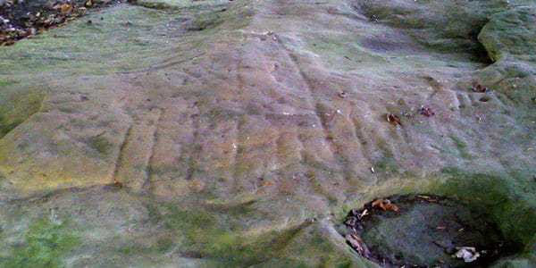 Faint etchings of parallel lines across a flat stone surface. 