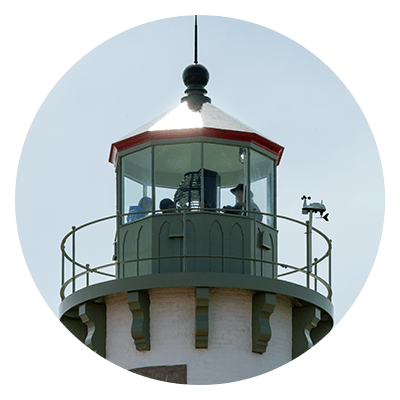 A group of people in the lantern room of the tower of Tawas Point Lighthouse.