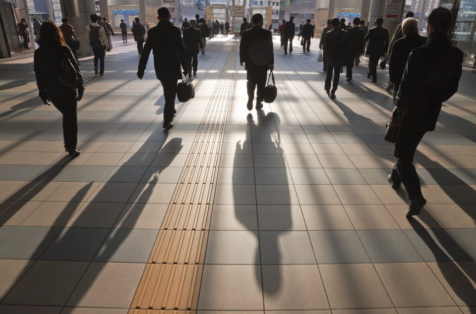People walking and casting long shadows