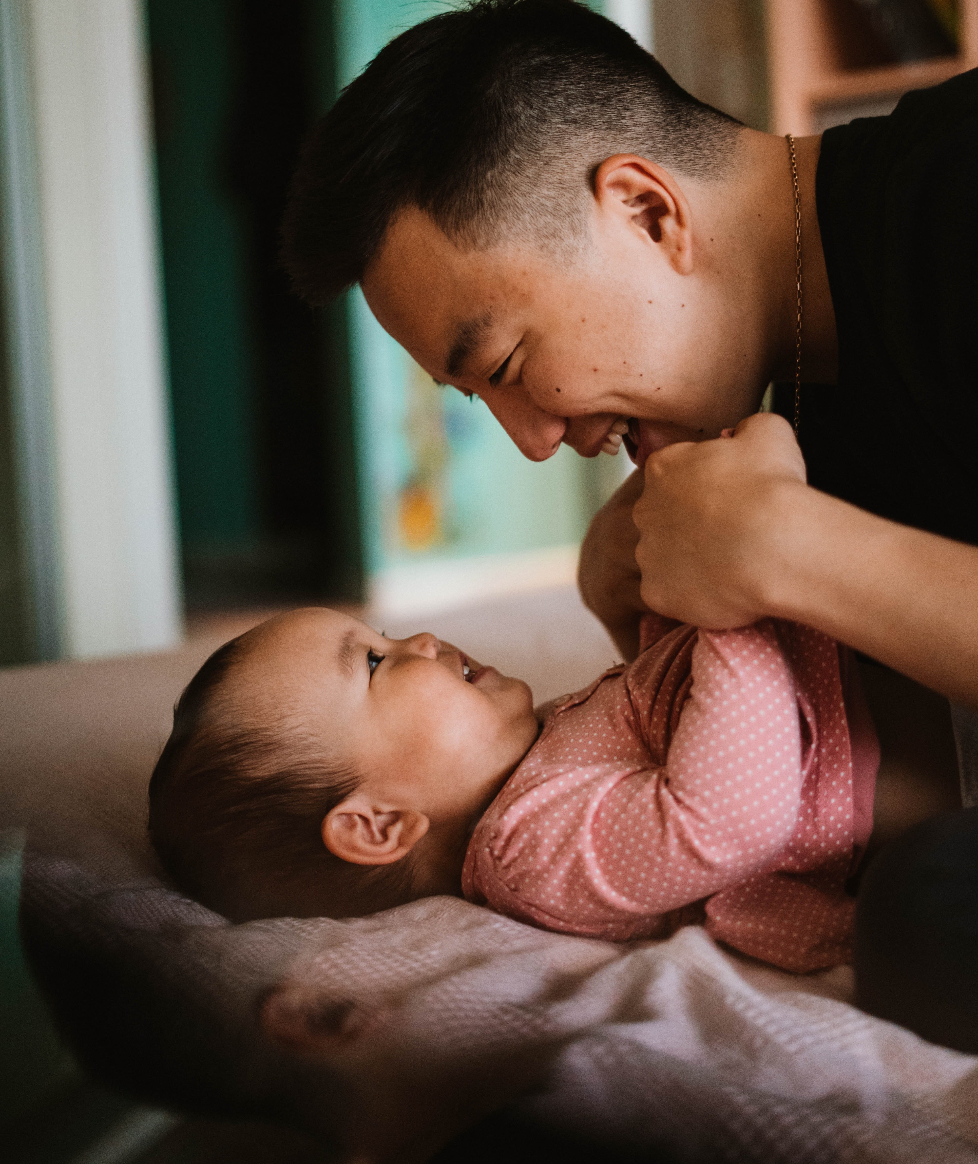caregiver interacting with baby and smiling