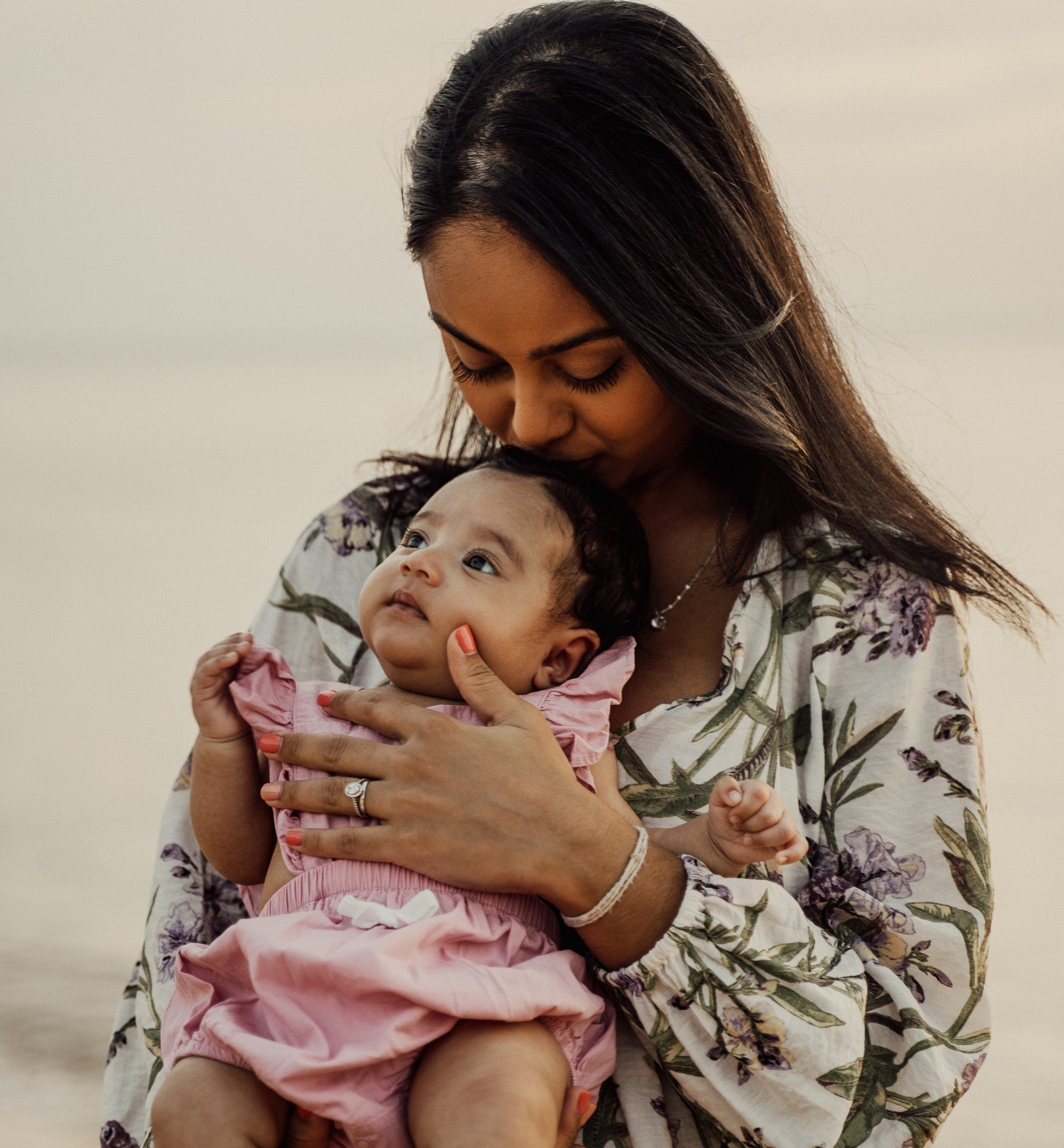 caregiver kissing child on head