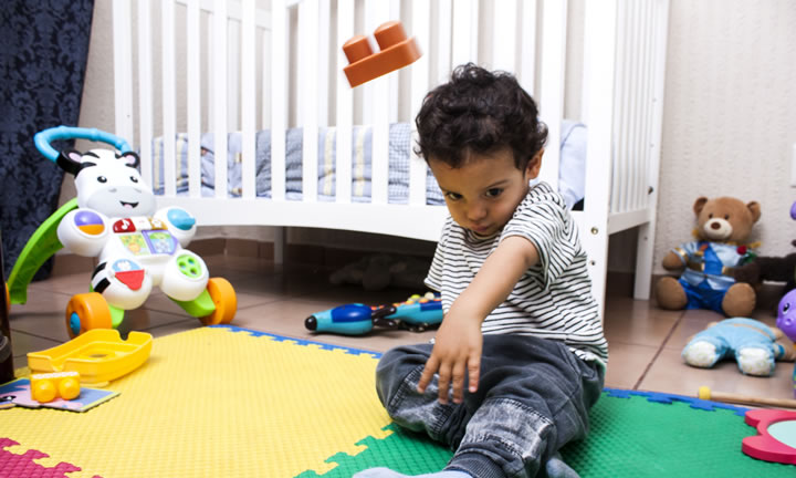 Young child throwing a large Lego style block