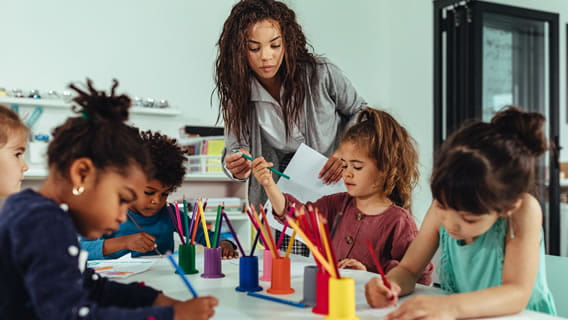 two preschool children drawing with colored pencils