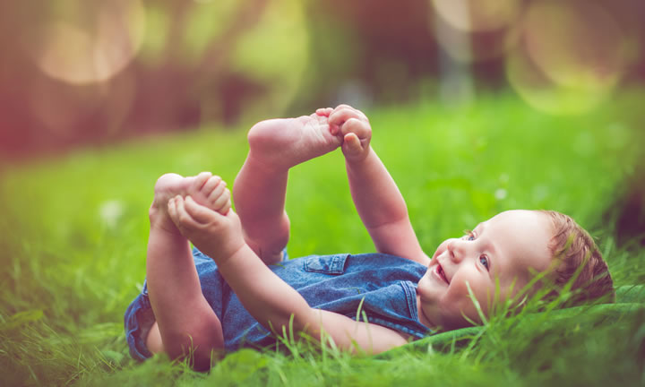 baby laying in grass