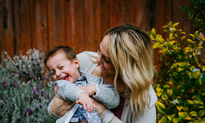 mom holding smiling toddler son